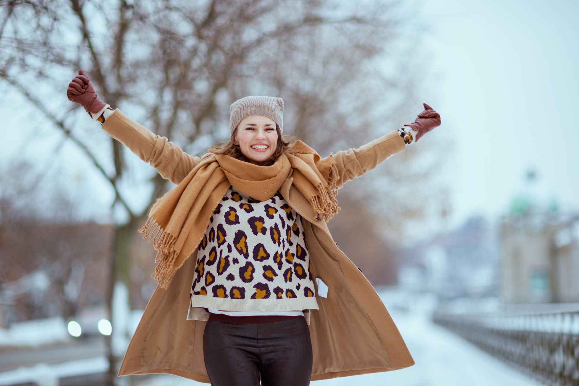 Frau mit ausgebreiteten Armen an einem Wintertag