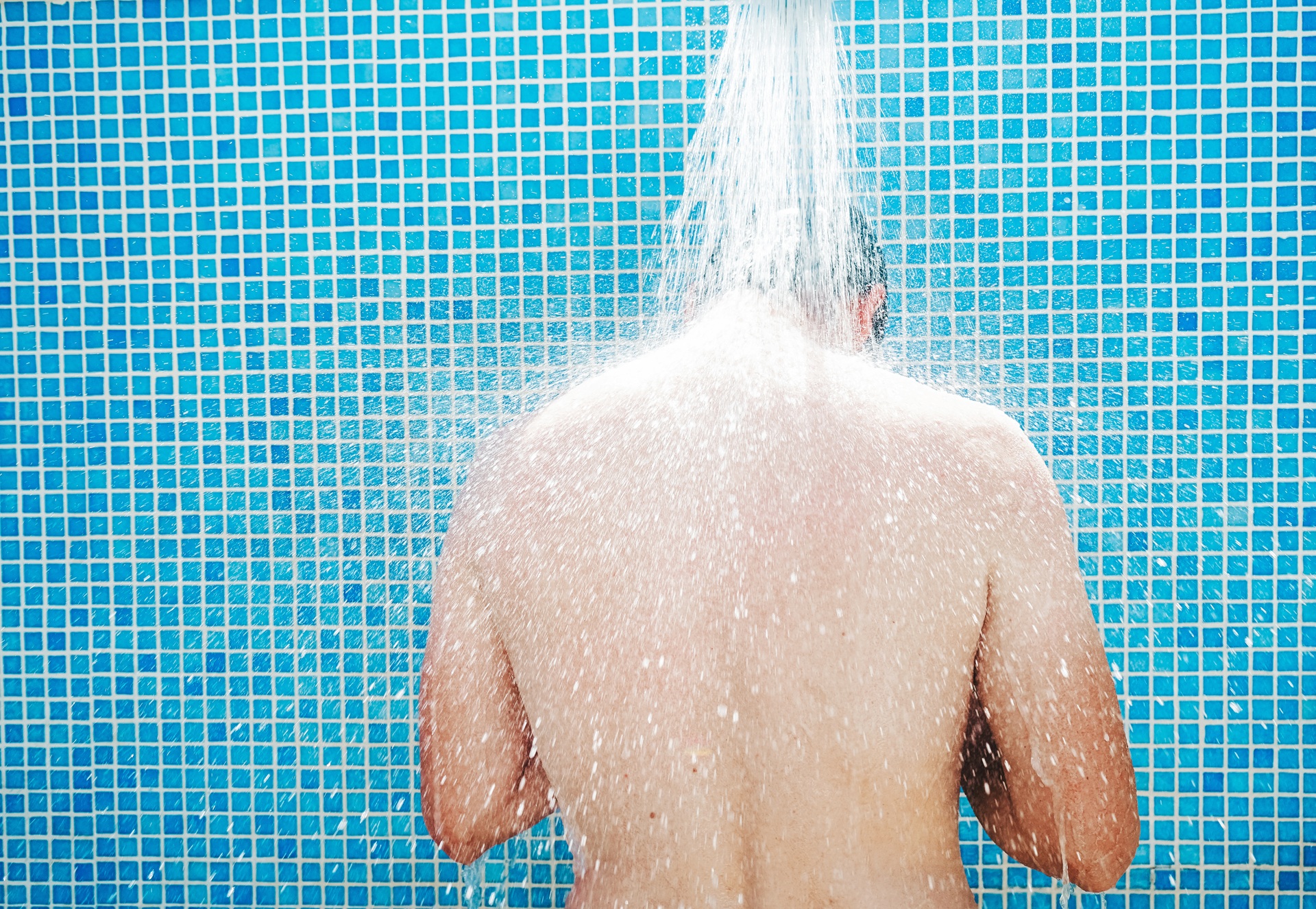 Mann unter kaltem Wasserstrahl | Duschrückwand